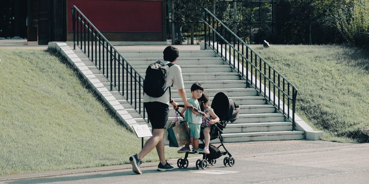 日本建築の前を歩く子ども連れの家族